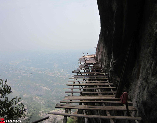 Workers build a plank road on the side of Shifou Mountain, Huna